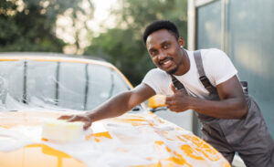 Homem negro lavando carro amarelo