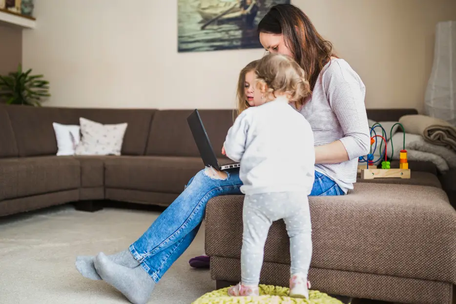 mãe com notebook no colo mostrando algo na tela